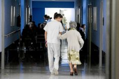 Una enfermera acompaa a una persona mayor en un centro hospitalario.