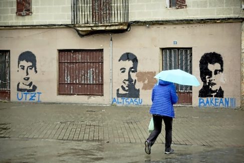 Una vecina pasa ante un fachada con pintadas de los presos de Alsasua