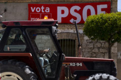Un tractor pasa ante un cartel electoral del PSOE, esta semana en Quintanilla de Onsimo (Valladolid)