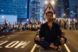 Un manifestante se sienta en el centro de la carretera tras las protestas en Hong Kong.