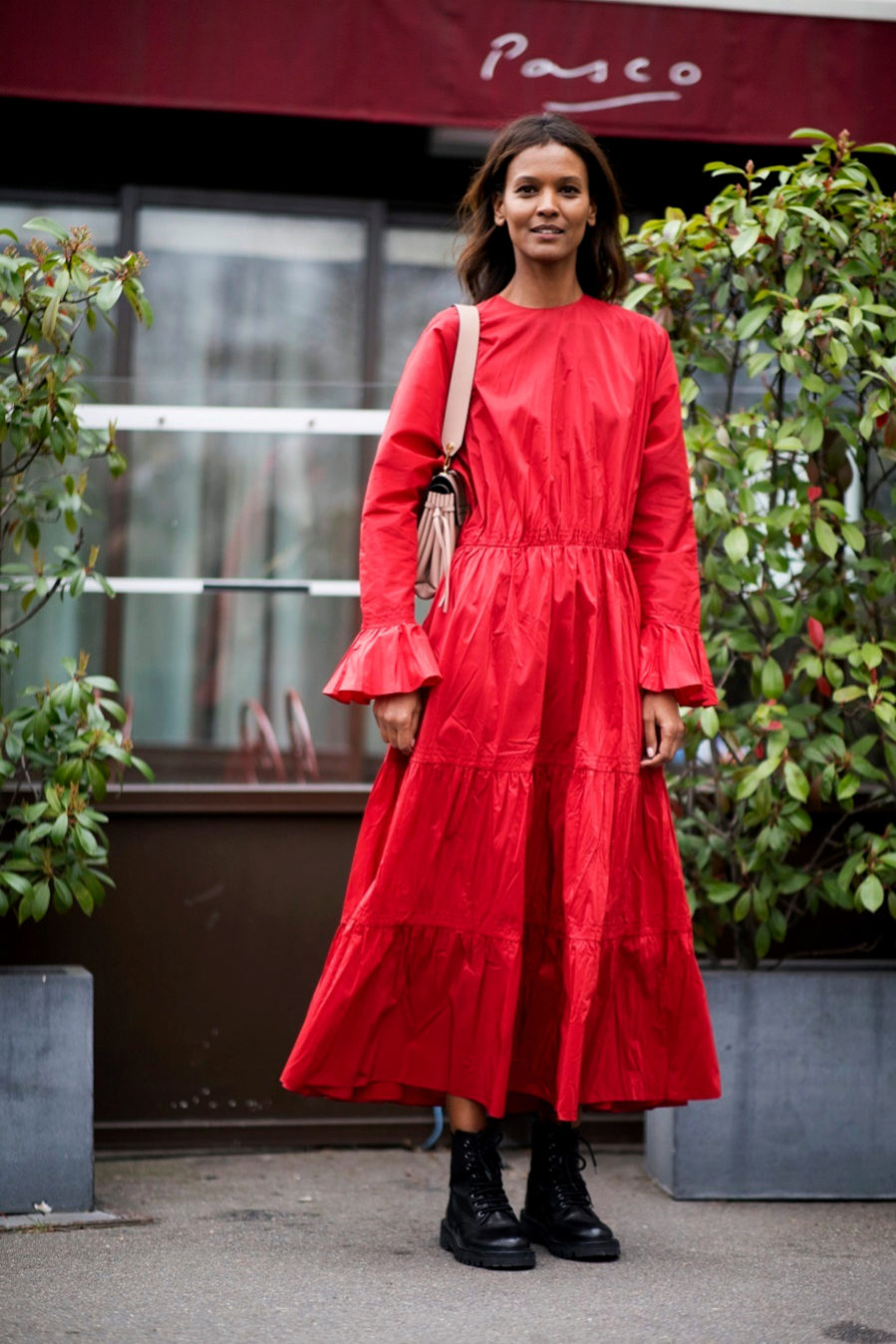La top Liya Kebede combina su vestido midi rojo con botas Dr Martens.