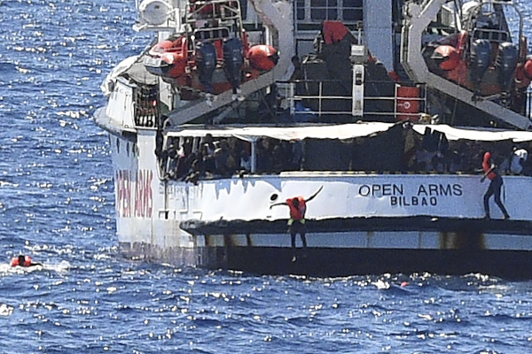Varios migrantes saltan por la borda del Open Arms.