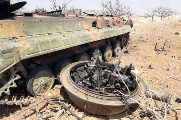 A damaged military tank is seen in Idlib countryside