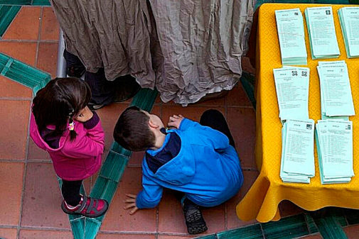 Dos nios cotillean una cabina electoral en Andaluca
