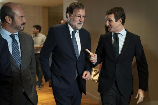 El presidente del PP, Pablo Casado, conversa con Mariano Rajoy en un...