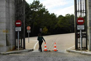 Una guardia civil coloca unos conos para impedir el acceso al recinto de la baslica del Valle de los Cados.