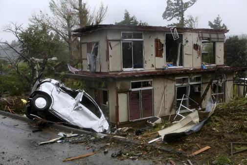 Vista de un vehculo y una casa daados despus de que un tornado...