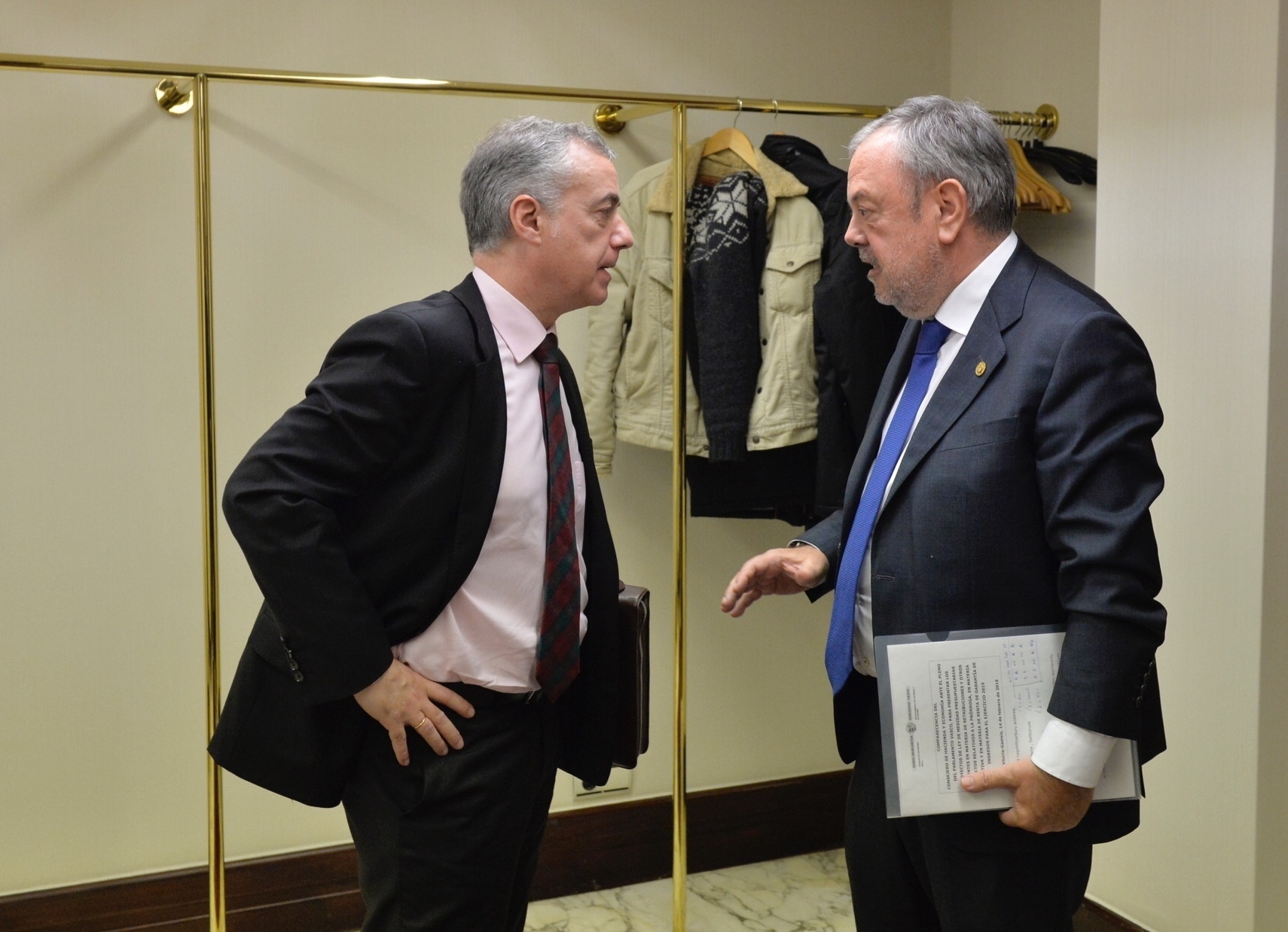 El lehendakari Urkullu y el consejero Pedro Azpiazu conversan en los pasillos del Parlamento Vasco.