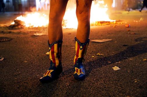 Un manifestante independentista con botas decoradas con la estelada...