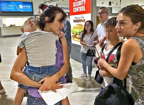 Juana Rivas con uno de sus hijos en brazos, antes de entregarlos a su...