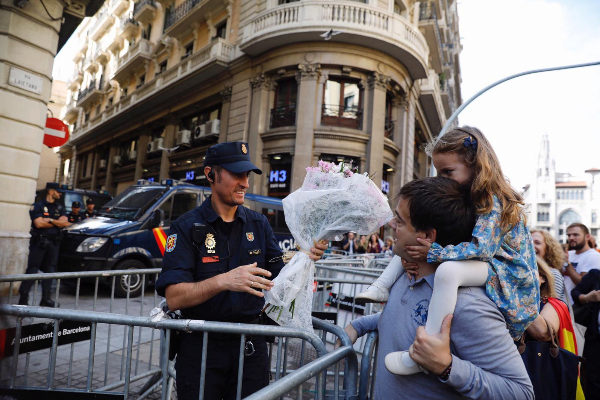 Un hombre y su hija entregan un ramo de flores a un polica en la...