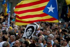 arios manifestantes portan una bandera 'estelada' junto a una fotografa del expresidente de la Generalitat de Catalua, Carles Puigdemont.