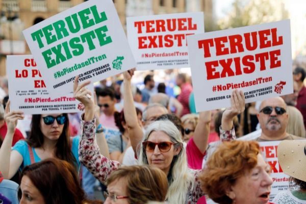 Una manifestante exhibe sendos carteles con el lema &amp;quot;Teruel existe&amp;quot;.