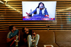 Dos jvenes iraques miran una televisin en la que informan de la muerte de Abu Bakr al Bagdadi.