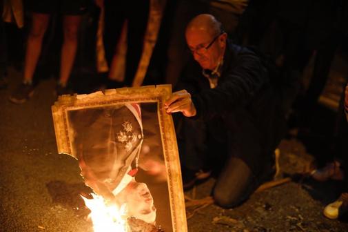 Un hombre quema una foto de Felipe VI con motivo de la entrega de...