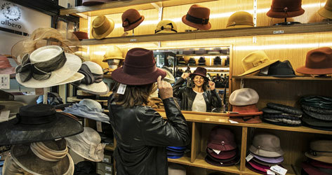 Una clienta se prueba una prenda de Sombreros Albero.