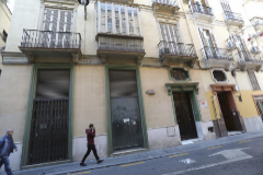 Dos viandantes pasan junto al local comercial ubicados en el edificio donde el PSOE de Mlaga tiene una de sus sedes, en la calle Olleras.