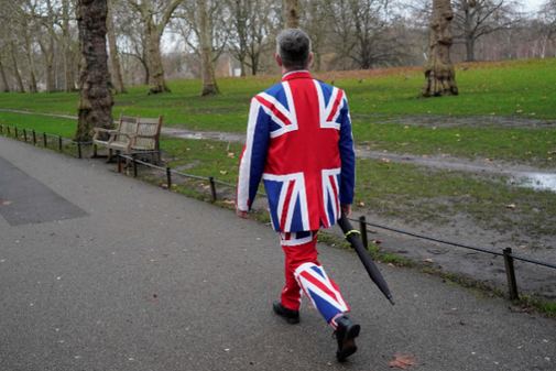Un hombre con un traje de la bandera del Reino Unido pasea por...