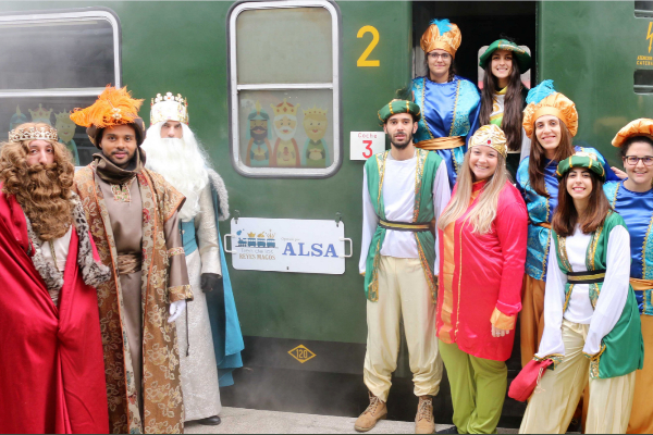 Melchor, Gaspar y Baltasar con sus pajes, junto al tren de los Reyes Magos.