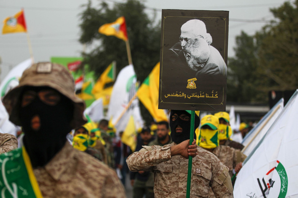 Paramilitares iraques y de Hezbollah sostienen un retrato de Soleimani.