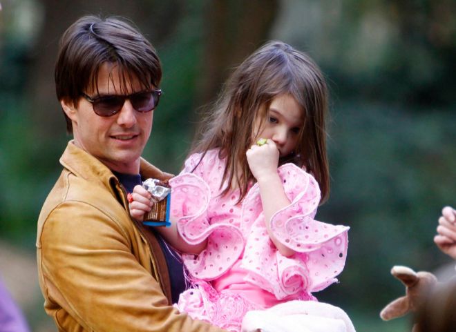 Tom Cruise lleva en brazos a su hija Suri, con vestido de Lina.