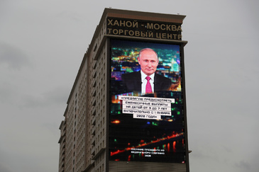 A screen shows a quote from Russian President <HIT>Putin</HIT>'s address to the Federal Assembly in Moscow