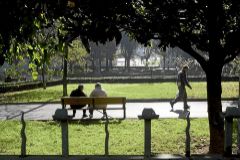 Dos hombres descansan en un banco del parque Dos Hermanos de Barakaldo.