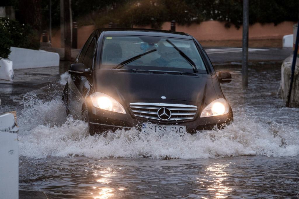Un coche transita una calle inundada de Cala de Bou (Ibiza).