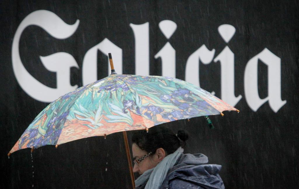 Una mujer caminaba bajo la lluvia en una calle del centro de A Corua.