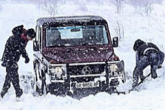 Dos hombres intentan sacar su todo terreno atrapado en la nieve cerca de Yecla, Murcia.