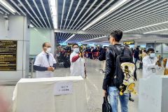 Trabajadores de un aeropuerto chino controlan la temperatura de los viajeros.