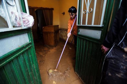 Una vecina del barrio de Campanillas limpia de agua y barro su casa tras la inundacin.