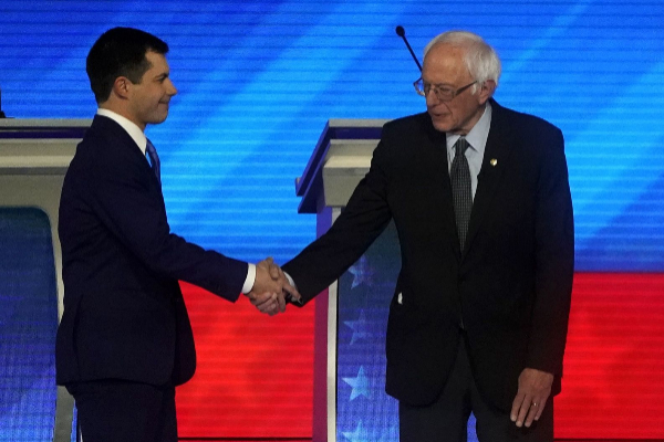Buttigieg (Izq.) saluda a Sanders (Der.) al inicio del 8ª debate demócrata, en New Hampshire.