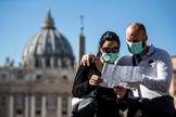 Dos turistas consultan un plano junto al Vaticano.