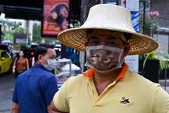 Vendedor en Bangkok, protegido con mascarilla.