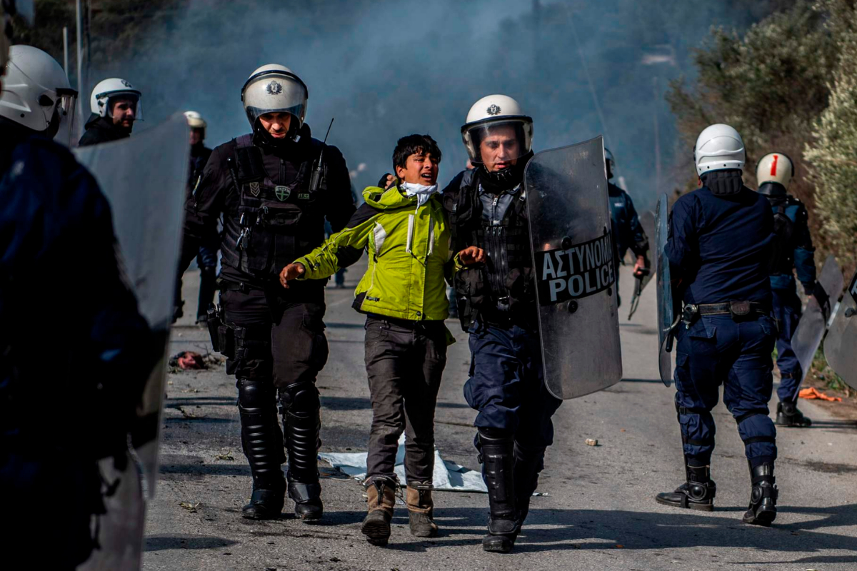 Antidisturbios griegos detienen a un migrante tras disturbios en la frontera.