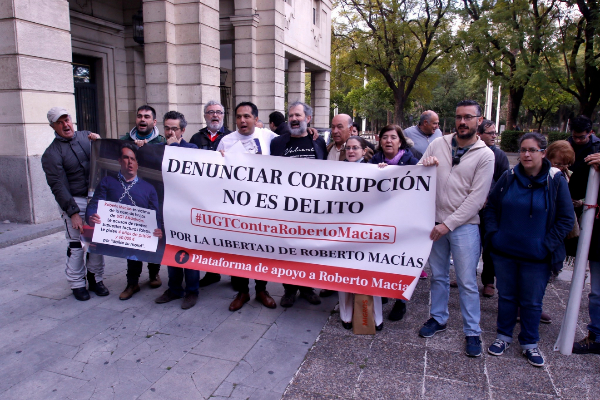 Roberto Macías y activistas contra la corrupción despliegan una pancarta a las puertas de los juzgados.