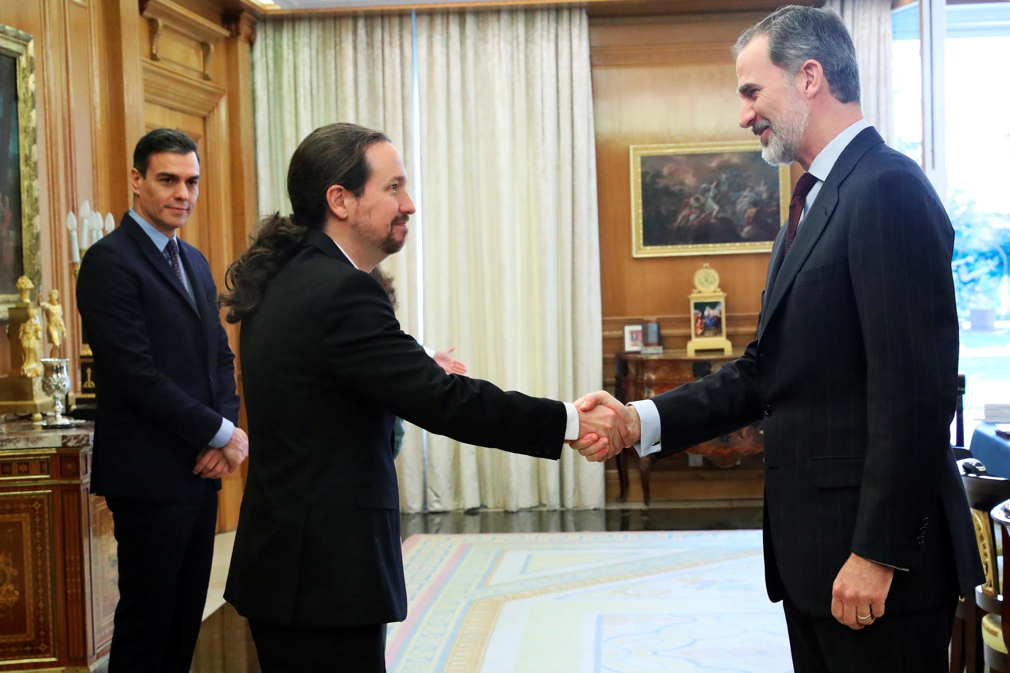 Pablo Iglesias saluda al Rey, en marzo de 2020, ante la atenta mirada del presidente del Gobierno, durante una reunión en el Palacio de La Zarzuela. EFE