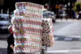 Un consumidor sale de una tienda con un carro lleno de papel higinico