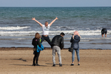 Un grupo de personas se hace fotografas festivas, este viernes, en la playa de la Malvarrosa de Valencia.