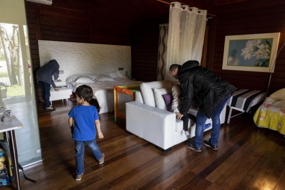 Una familia sin hogar en el interior de la casita de madera donde est alojada.