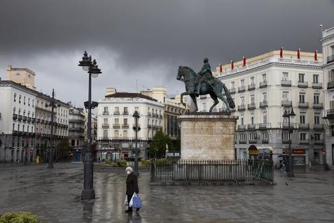 Una mujer camina por la Puerta del Sol de Madrid, desierta por el confinamiento decretado por el Estado de Alarma debido al coronavirus.
