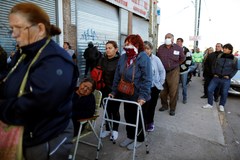 Pensionistas y receptores de ayudas esperan en la puerta de un banco, hoy en Buenos Aires.