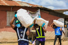 Volunteers carry sacks filled with food to distribute to vulnerable residents, during a lockdown by the authories in efforts to limit the spread of the coronavirus disease (COVID-19), in Lagos