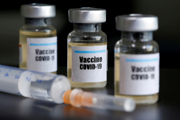 FILE PHOTO: FILE PHOTO: Small bottles labbeled with a " lt;HIT gt;Vaccine lt;/HIT gt; COVID-19" sticker and a medical syringe are seen in this illustration