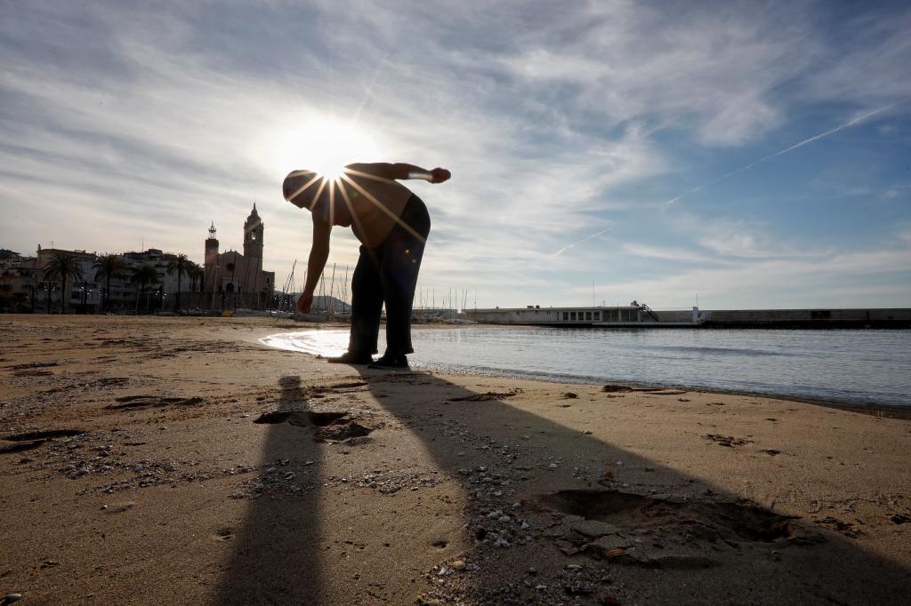 Un hombre haciendo deporte en la playa de Sitges. EFE
