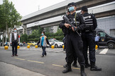 Policas vigilan la entrada de un instituto, en Wuhan.