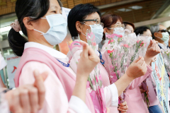 Nurses receive flowers and pose for a photo to celebrate International Nurse day in Taipei
