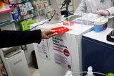 Un hombre recoge en una farmacia una de las mascarillas FPP2 que entrega  gratuitamente la Comunidad de Madrid.