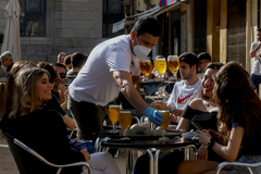 Un camarero atiende a unos clientes en una terraza